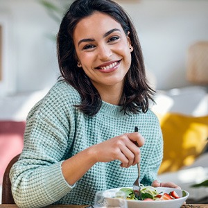 Woman smiling while eating lunch at home