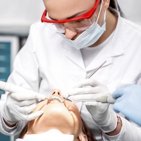 Dental team member giving a patient a dental cleaning