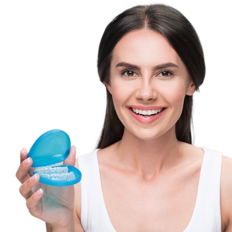 Smiling woman holding case for Invisalign aligners