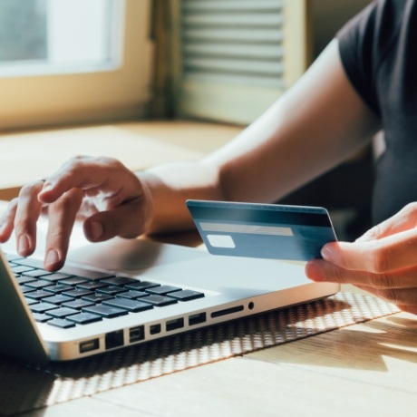 Person entering their credit card information on a laptop