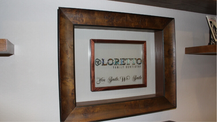 Framed artwork on wall that says Loretto Family Dentistry You Smile We Smile