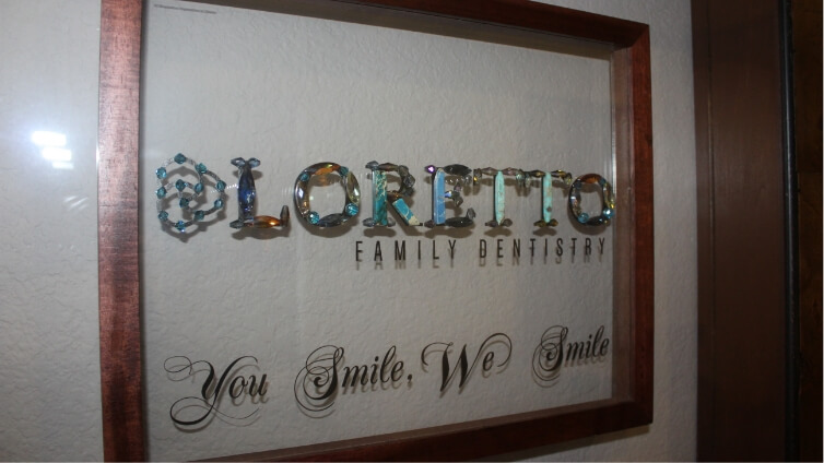 Close up of framed artwork on wall that says Loretto Family Dentistry You Smile We Smile