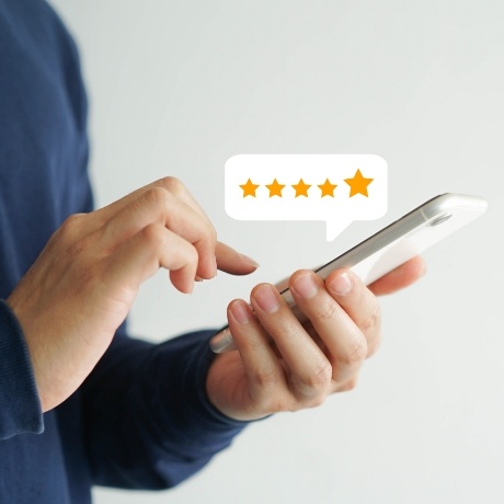 Person leaving a five star review on their phone