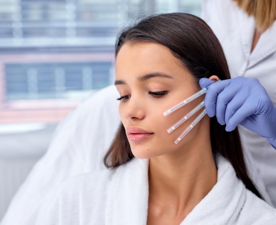 Woman in white bathrobe receiving Botox injection