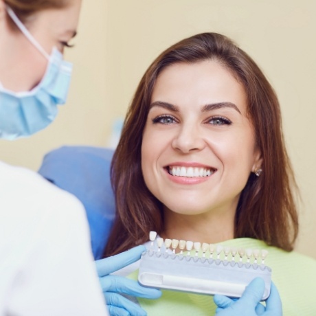 Smiling woman getting fitted for dental veneers