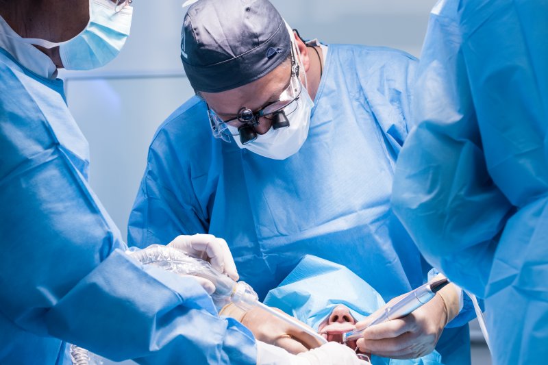 Trained dentists performing a dental implant surgery